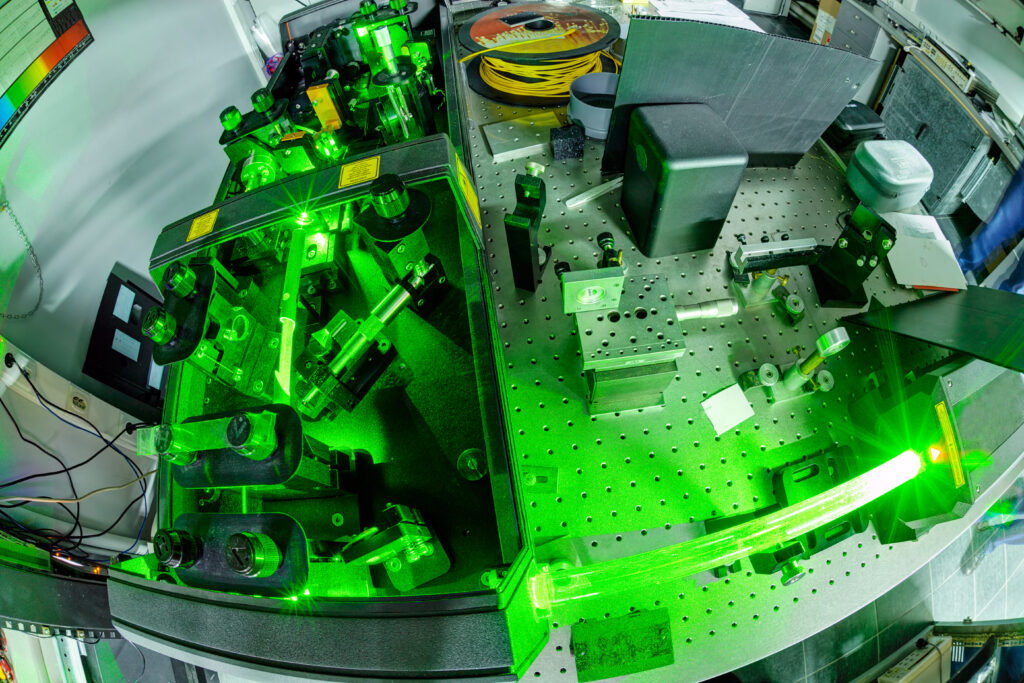 Green laser on optical table in a quantum optics lab.